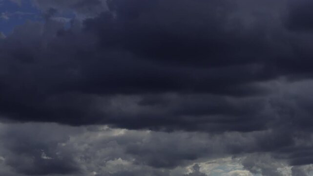 Timelapse of dark storm clouds rapidly forming and moving across the sky.