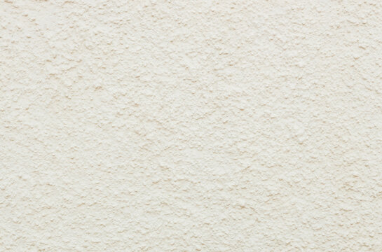 Beautiful view of textured street wall of pale yellow building.