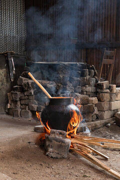 Steaming clay pot over flames in a rustic setting