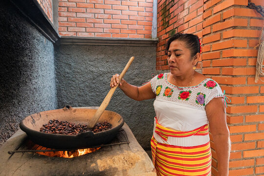Artisan Stirring Roasted Cacao in a Traditional comal