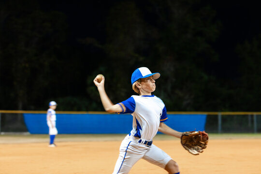 Young Fielder Throws Ball at Night During Baseball Game