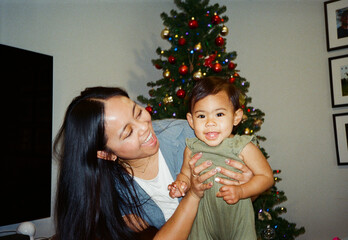 film family christmas mother and happy daughter by festive tree