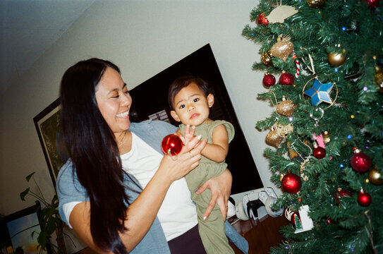 mother decorating christmas tree daughter at home direct flash film