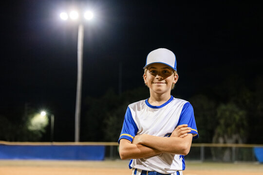 Young Baseball Player Poses on a Field at Night