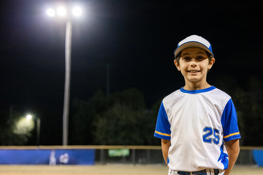 Child Stands on Baseball Field at Night for Portrait
