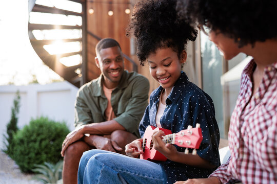 Family enjoys music together outdoors in the sunshine.