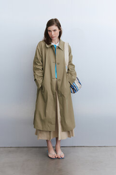 Full body portrait woman in trench coat with tote bag