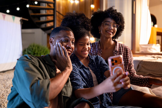 Daughter taking selfie with parents during outdoor evening
