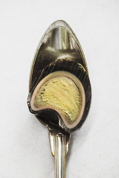A preserved egg in a Metal Spoon 