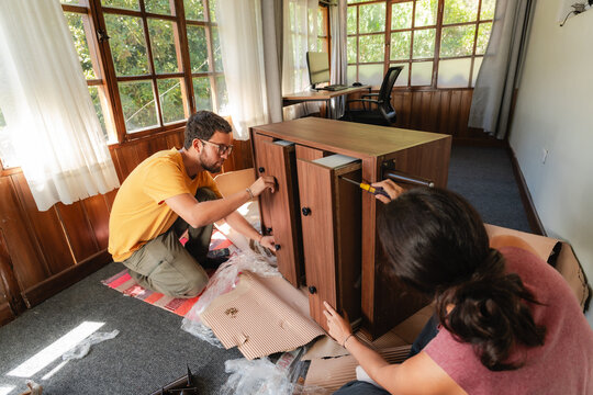 young couple Assembling Wooden Furniture at Home