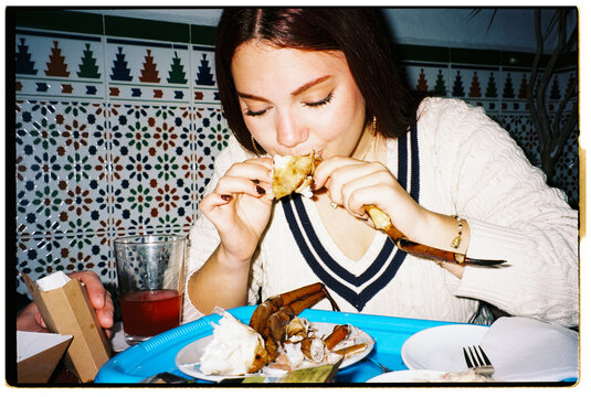 Woman Eating Crab Legs at Restaurant