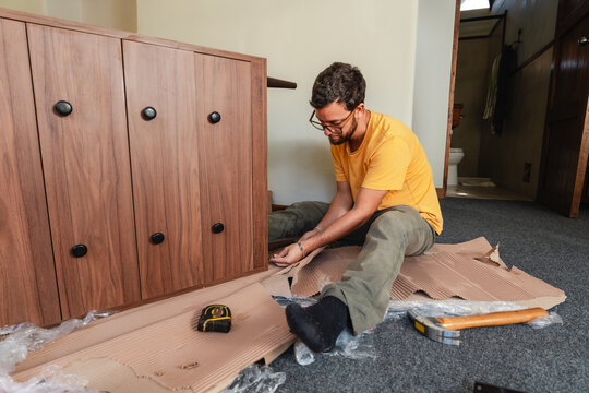 Young man Assembling Furniture in Bright Home 