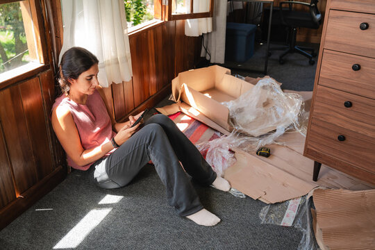 Young Woman Using Smartphone While Taking a Break at Home
