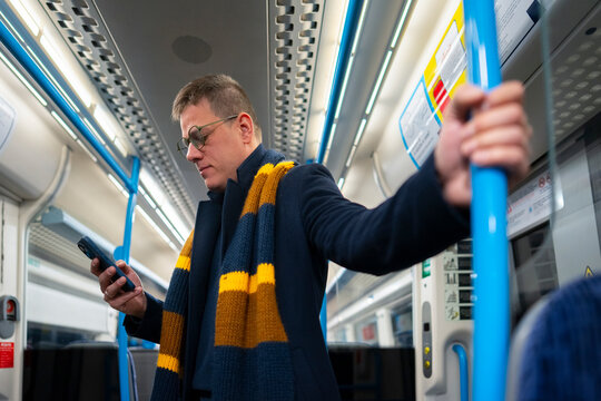 Man using smartphone while standing in train