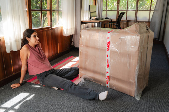 young Woman Unboxing Large Fragile Box at Home