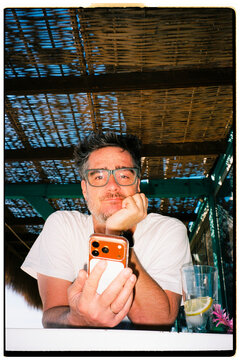 Man Using Smartphone at Beach Bar