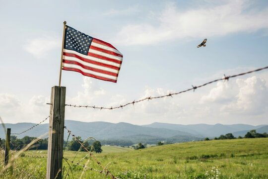 American flag waving on rural farm with mountain backdrop