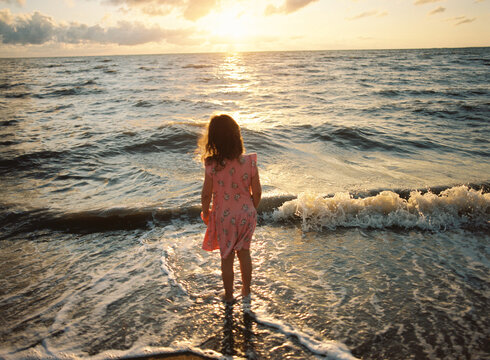 Young Child at Ocean Edge at Sunrise in Carmila Beach Queensland