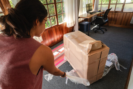 young Woman Unpacking Large Fragile Box at Home