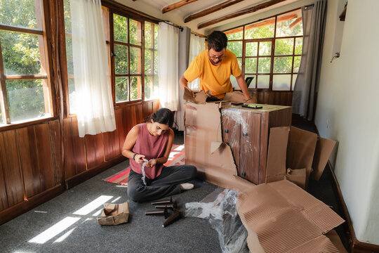 Young Couple Unboxing New Furniture Delivery at Home
