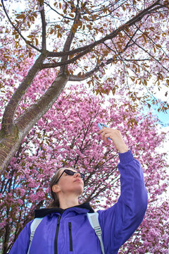 Low angle shot of woman taking photo with smartphone