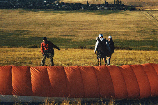 People prepare to fly a glider in open field
