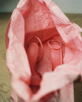 A pair of pink shoes in a pink bag 