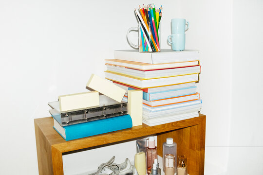 Daily life items books, coffee cups, shoes, folders in a shelf