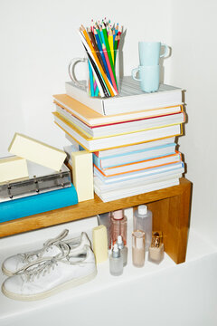 Daily life items books, coffee cups, shoes, folders in a shelf