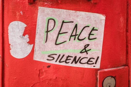 Message on a Red Wall About Peace and Silence in the City