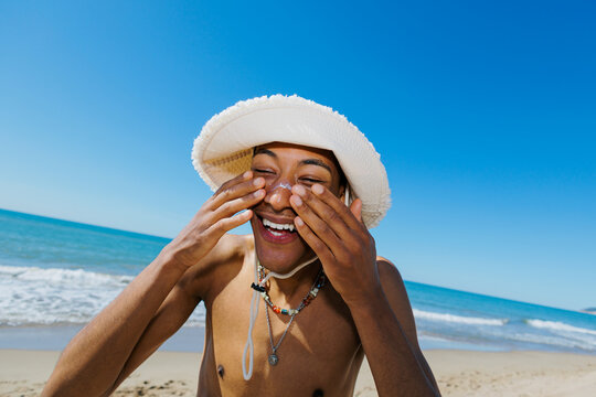 Man applying sunscreen on face at beach
