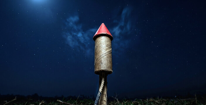 Large firework rocket on its cardboard launch in night sky