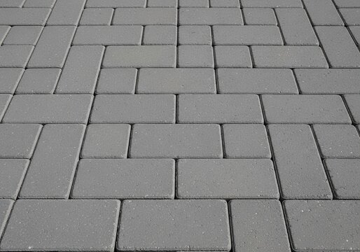 Grey stone paver blocks arranged in a geometric pattern on a sidewalk ground