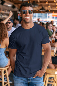 dark navy blue bella canvas t-shirt mockup, an athletic man wears it grinning, wearing sunglasses at a rowdy and sunny outdoor bar for the 4th of july, front view, photorealistic