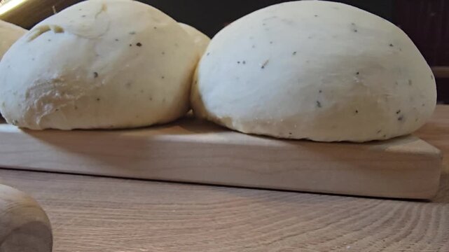 Close-up of dough with spices for chapatis on a board with a rolling pin. Selective focus.