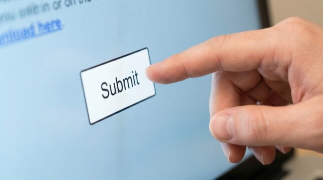 Close up view of finger pressing submit button on computer screen interface in home office.