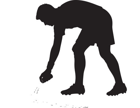 Athlete silhouette bends forward to perform a precise action on the ground.