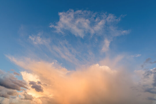 Sun burst orange clouds in a blue sky cloudscape background