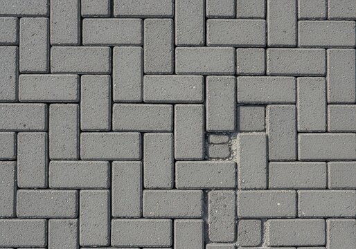 Top view of grey stone brick paving pattern on a sidewalk or driveway