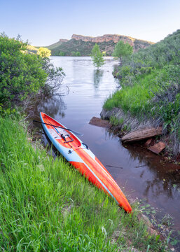 Long and narrow racing stand up paddleboard on a calm mountain lake in early summer - Horsetooth Reservoir in Fort Collins, Colorado, fitness and recreation concept
