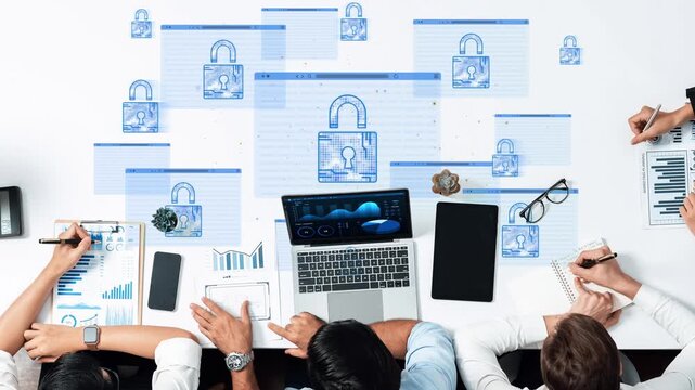 Business meeting focused on cybersecurity strategy with digital padlocks and data analysis on laptops and notepads in a modern office environment. Entropy.