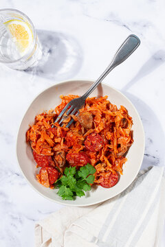 Bigos, Polish dish bigos, on a marble table, stewed meat with cabbage, chorizo sausages, mushrooms, homemade, without people,
