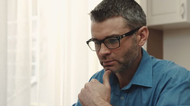 Young Caucasian man with gray hair communicating with colleague, using Skype. Man talking, sharing experience. Young businessman working at home. Close-up.