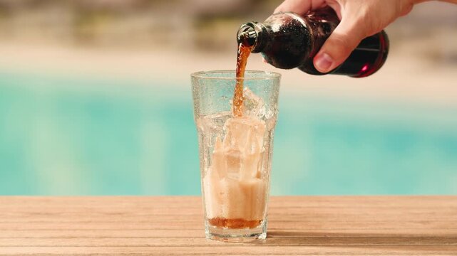 Cola opening and cheers, drinks, people and lifestyle concept - close up of happy woman drinking cola in sunset beach bar in hotel. 