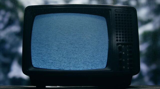 Retro TV, vintage television In a nostalgic setup, a retro TV displays grain on screen, scary halloween night device good for chroma key and green screen.