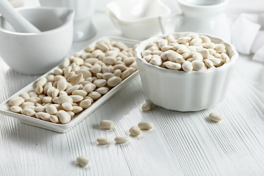 Dried white beans on a white table.