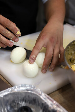 chef en la cocina con huevos cocidos que va a picar como ingrediente de elaboraci&oacute;n e plato