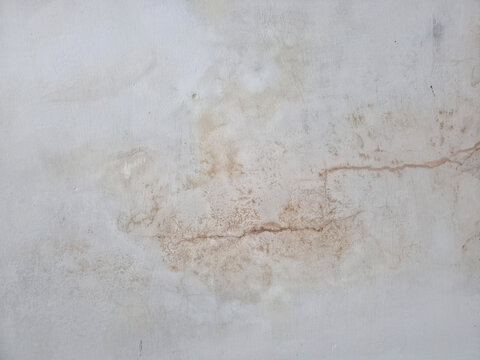 Water damaged wall with brown stains and a crack