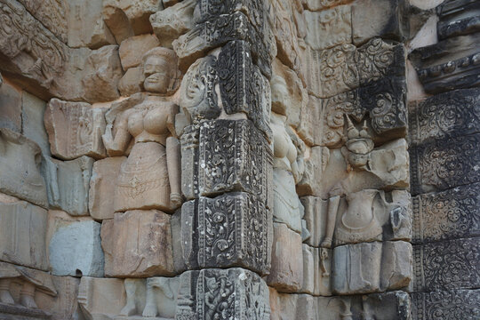 Ancient stone bas-reliefs depicting Apsaras in a temple complex in Cambodia