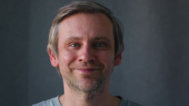 Smiling middle aged man 40 years old standing in office, portrait. Smiling blue eyes office worker, freelancer.